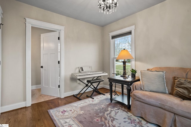 sitting room with hardwood / wood-style flooring and an inviting chandelier