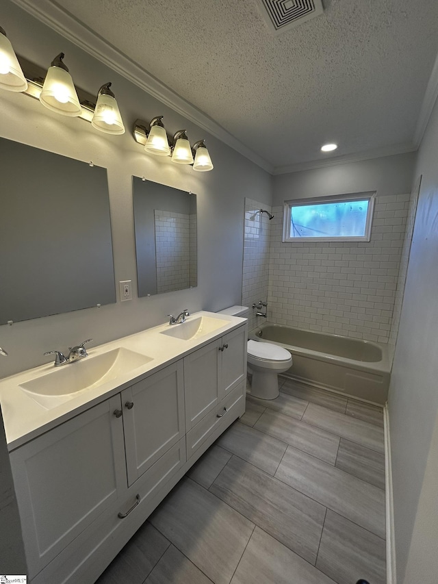 full bathroom featuring vanity, a textured ceiling, ornamental molding, and tiled shower / bath