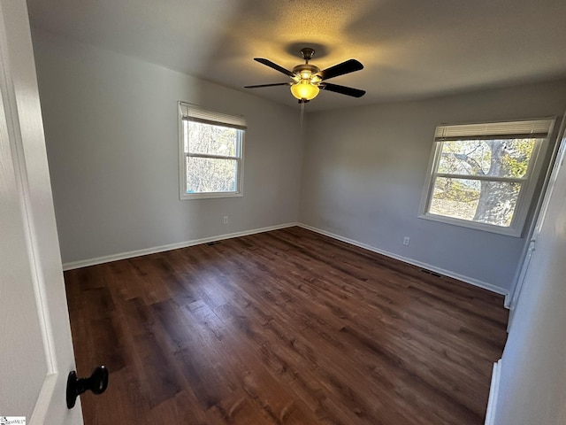 spare room with dark wood-type flooring and ceiling fan