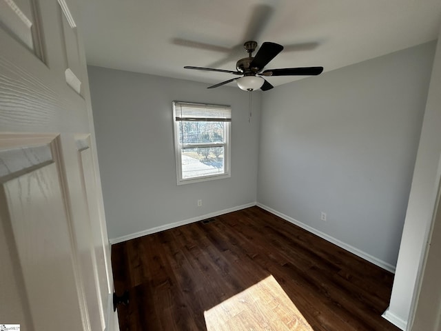 spare room featuring dark hardwood / wood-style flooring and ceiling fan