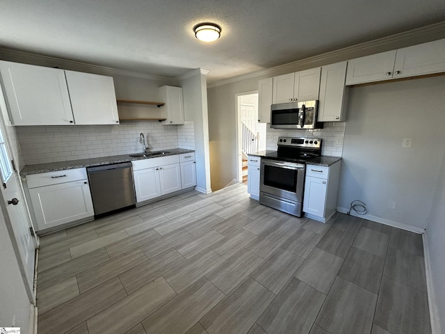 kitchen with white cabinetry, sink, dark stone counters, and appliances with stainless steel finishes