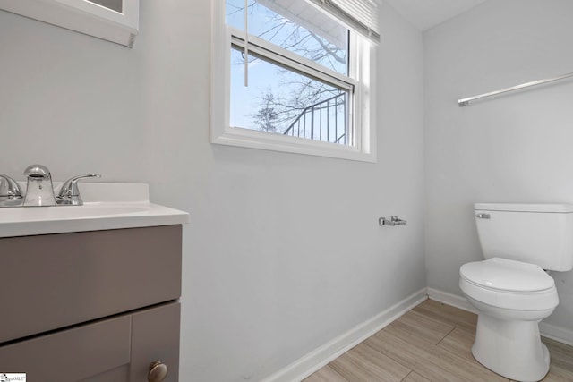 bathroom with vanity, toilet, and hardwood / wood-style floors