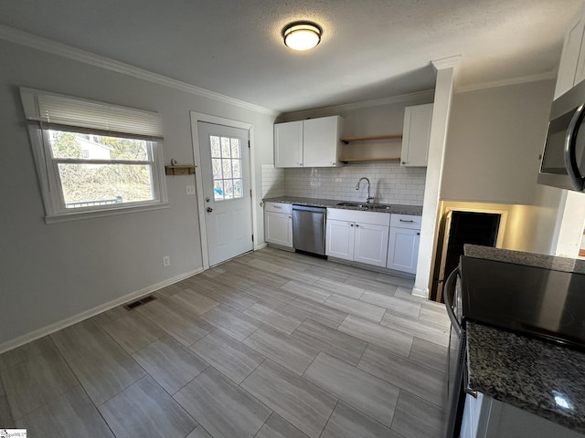 kitchen featuring stainless steel appliances, white cabinetry, sink, and tasteful backsplash