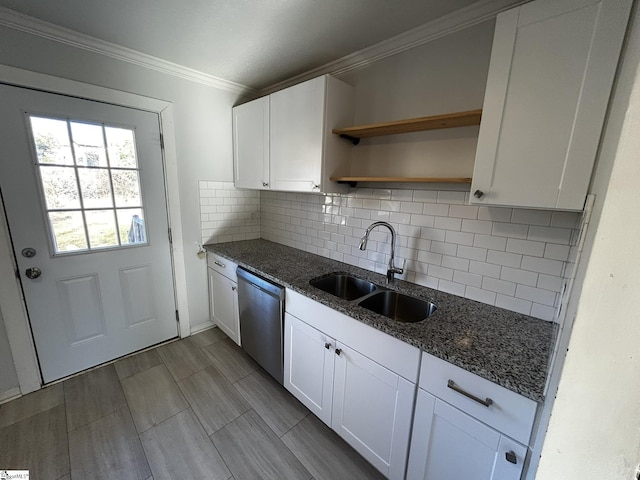 kitchen with white cabinetry, stainless steel dishwasher, sink, and dark stone countertops