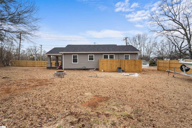 rear view of property featuring an outdoor fire pit