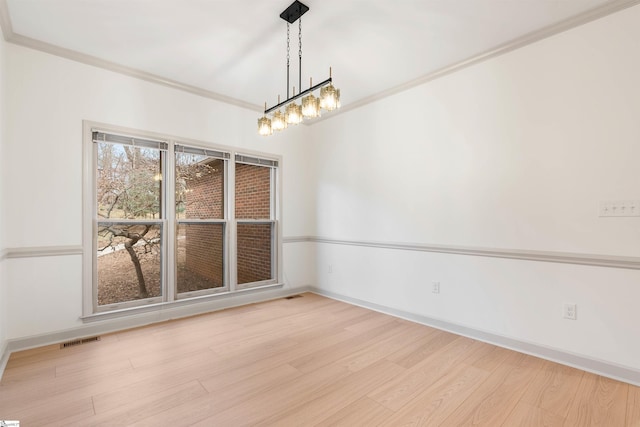 unfurnished dining area featuring crown molding and light wood-type flooring