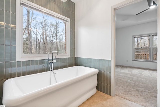 bathroom featuring a bathing tub, tile patterned flooring, and tile walls