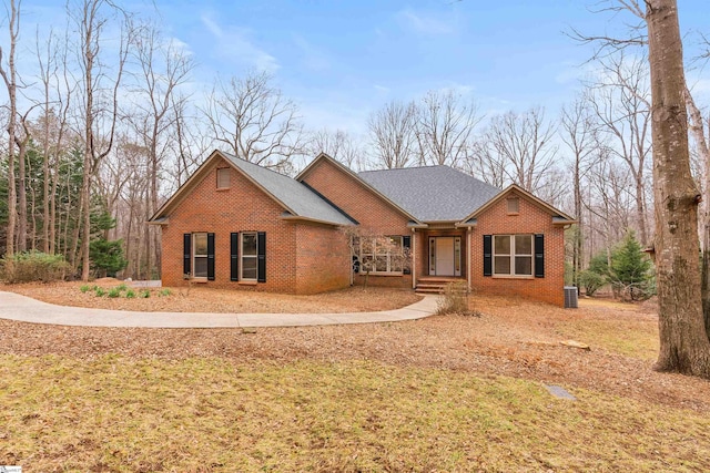 ranch-style house featuring cooling unit and a front lawn