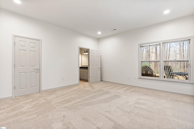 unfurnished bedroom with light colored carpet and ensuite bathroom