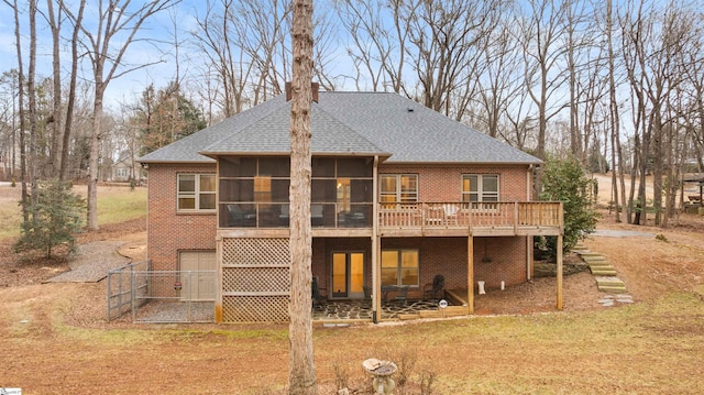 back of house featuring a garage, a sunroom, a yard, and a deck