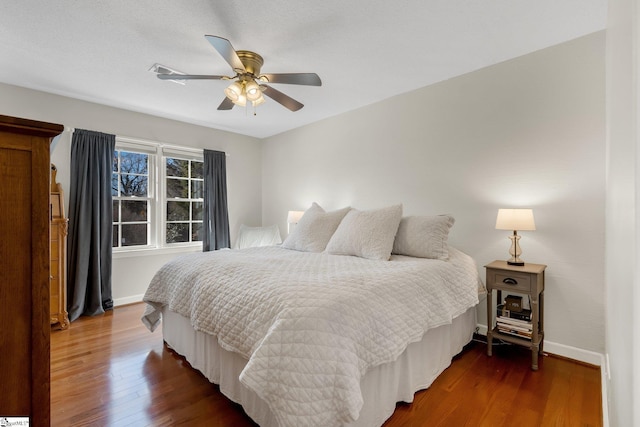 bedroom with dark hardwood / wood-style floors and ceiling fan