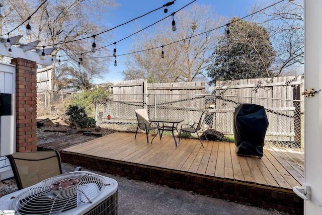 wooden deck featuring cooling unit and a grill