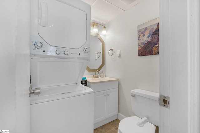 bathroom with vanity, stacked washer / drying machine, and toilet