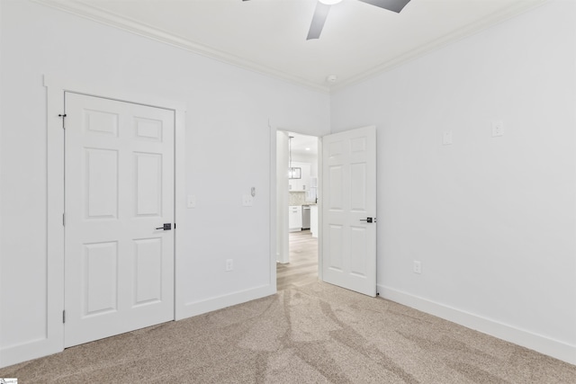 unfurnished bedroom featuring crown molding, ceiling fan, and light carpet