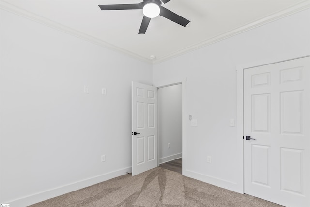 unfurnished bedroom with ceiling fan, ornamental molding, and carpet floors