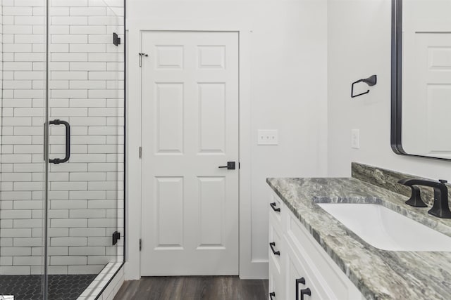 bathroom with vanity, an enclosed shower, and hardwood / wood-style floors