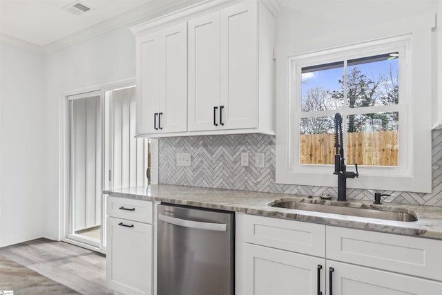 kitchen with sink, light stone countertops, ornamental molding, white cabinets, and stainless steel dishwasher