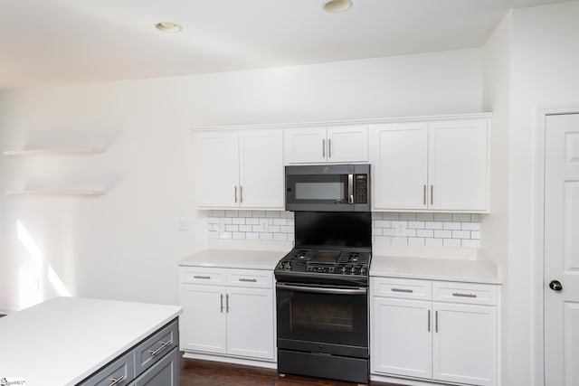 kitchen with black range with gas cooktop, gray cabinetry, white cabinetry, dark hardwood / wood-style floors, and decorative backsplash