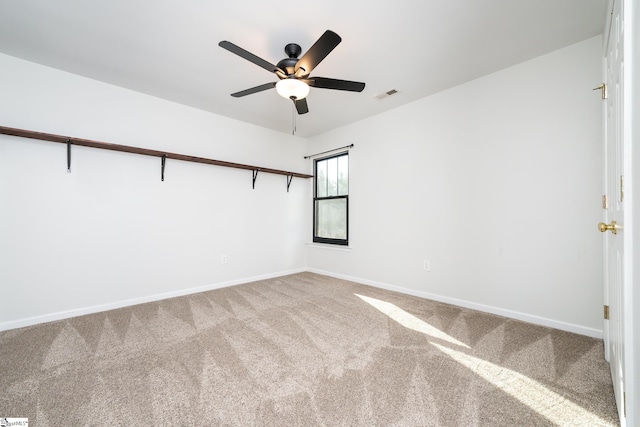 unfurnished room with ceiling fan and carpet