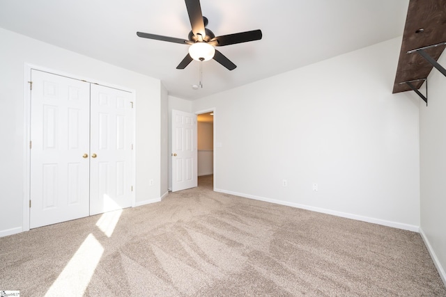 unfurnished bedroom with carpet floors, a closet, and ceiling fan