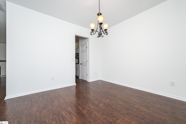 unfurnished room with dark wood-type flooring and a notable chandelier