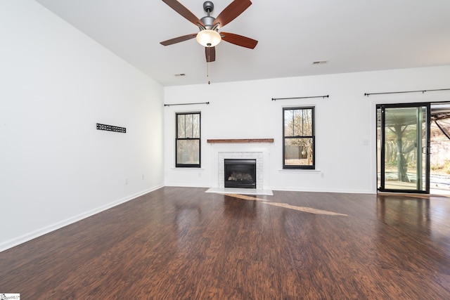 unfurnished living room with a fireplace, dark wood-type flooring, and ceiling fan