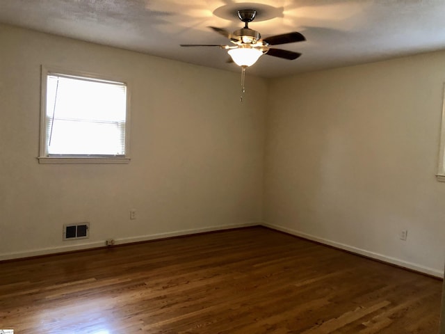 empty room with dark wood-type flooring and ceiling fan