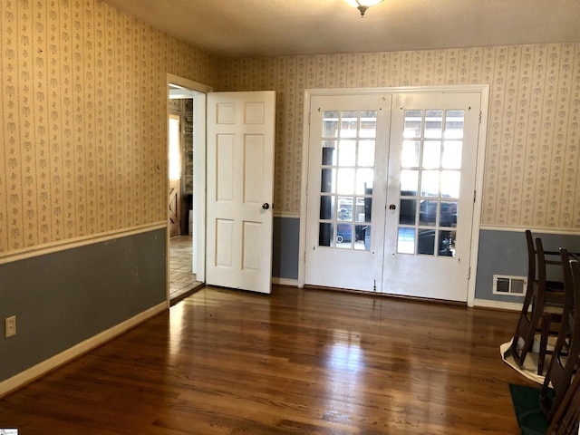 unfurnished room with french doors, dark hardwood / wood-style floors, and a textured ceiling