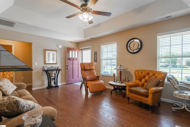 living room featuring a tray ceiling, dark hardwood / wood-style floors, and ceiling fan