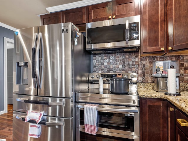 kitchen with appliances with stainless steel finishes, tasteful backsplash, crown molding, light stone countertops, and dark wood-type flooring