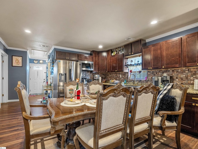 kitchen featuring appliances with stainless steel finishes, dark hardwood / wood-style flooring, decorative backsplash, light stone counters, and crown molding