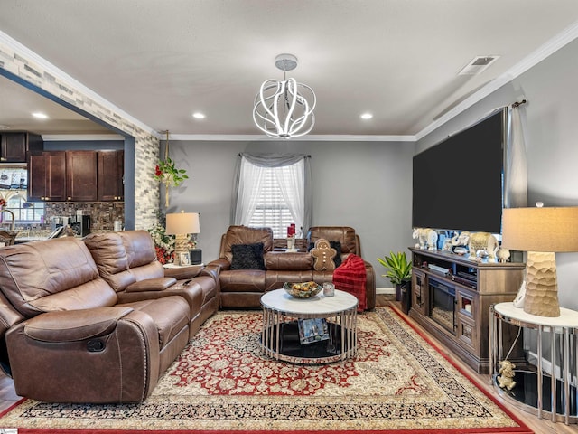 living room with hardwood / wood-style flooring, ornamental molding, and an inviting chandelier