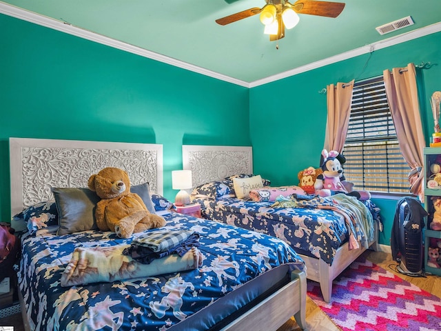 bedroom with hardwood / wood-style flooring, ornamental molding, and ceiling fan