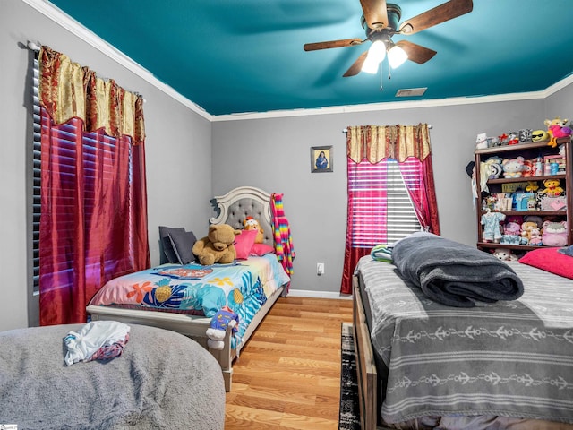 bedroom featuring hardwood / wood-style flooring, crown molding, and ceiling fan