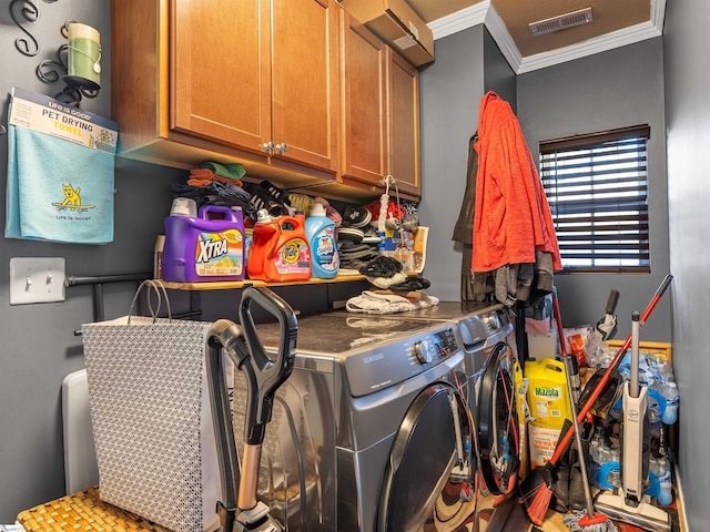 laundry area with crown molding, cabinets, and washing machine and clothes dryer