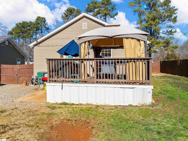 back of house with a yard, a gazebo, and a wooden deck