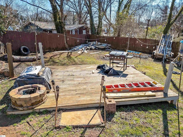 wooden deck with grilling area and an outdoor fire pit