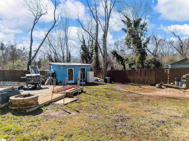 view of yard with a fire pit, an outdoor structure, and a deck