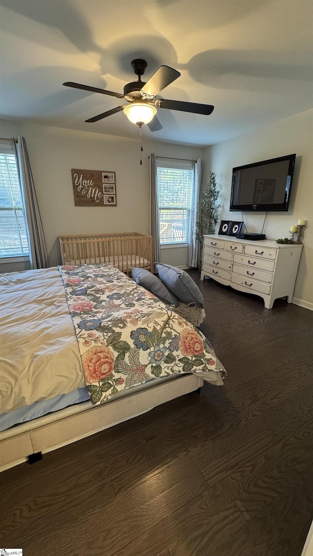 bedroom with dark hardwood / wood-style floors and ceiling fan