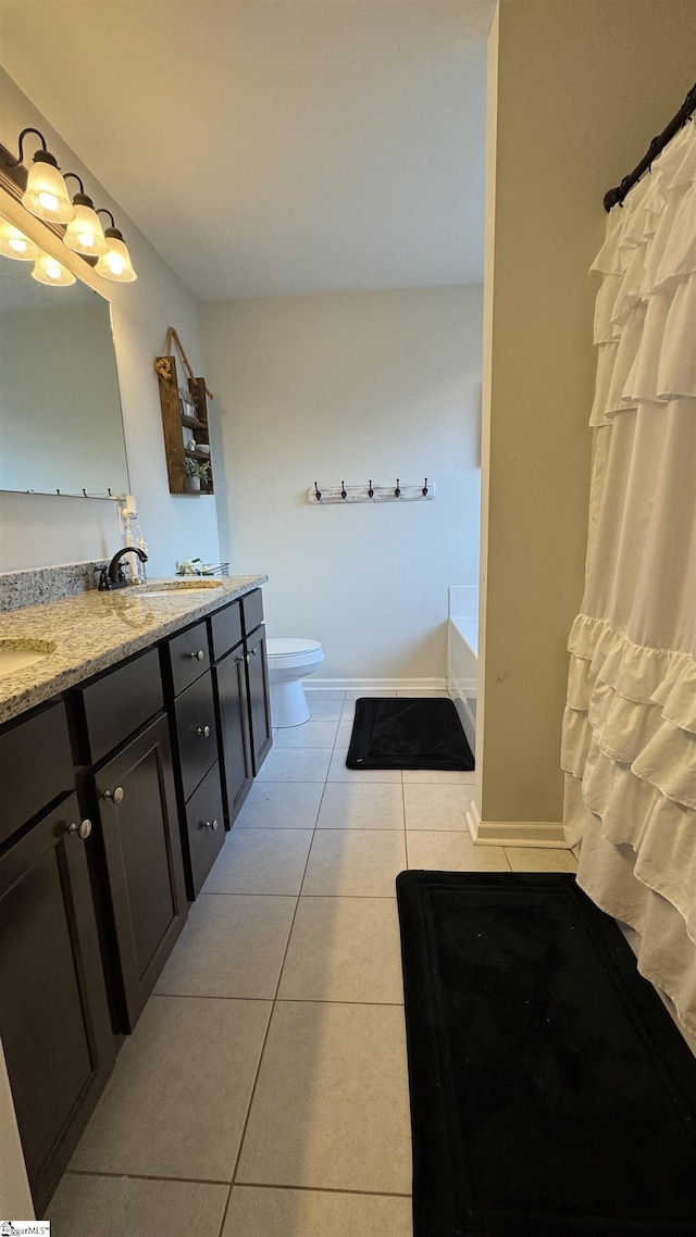 bathroom featuring vanity, a bathtub, tile patterned floors, and toilet