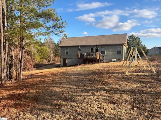 rear view of property featuring a wooden deck and a playground