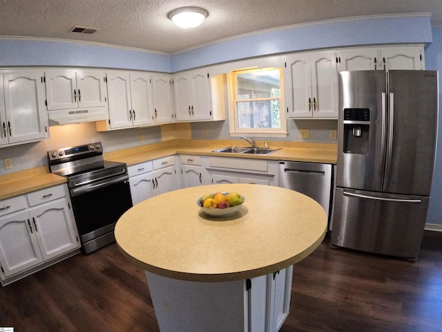 kitchen featuring sink, white cabinetry, stainless steel appliances, a textured ceiling, and dark hardwood / wood-style flooring