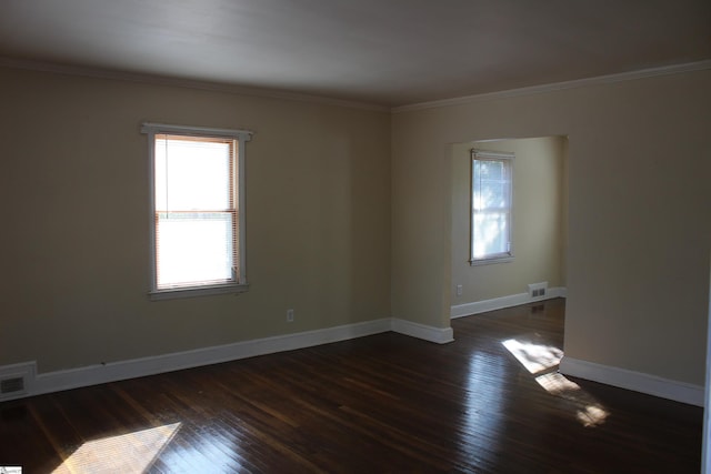 spare room featuring ornamental molding and dark hardwood / wood-style flooring