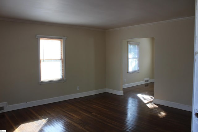 empty room with ornamental molding and dark hardwood / wood-style flooring