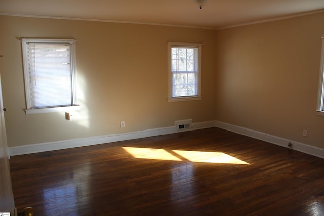 empty room featuring crown molding and dark hardwood / wood-style flooring