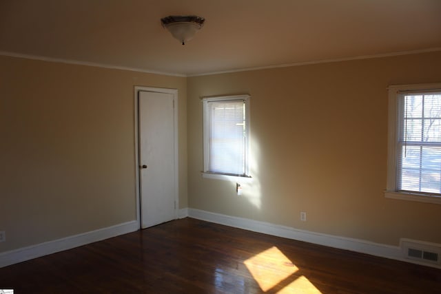 spare room featuring dark wood-type flooring and ornamental molding