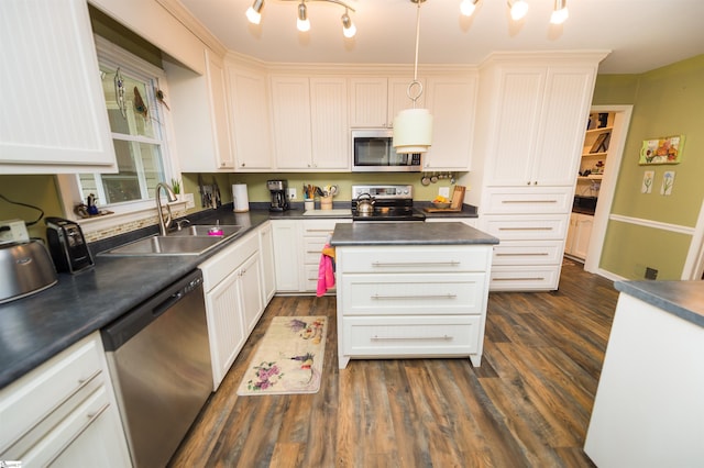 kitchen featuring appliances with stainless steel finishes, white cabinetry, sink, hanging light fixtures, and dark wood-type flooring