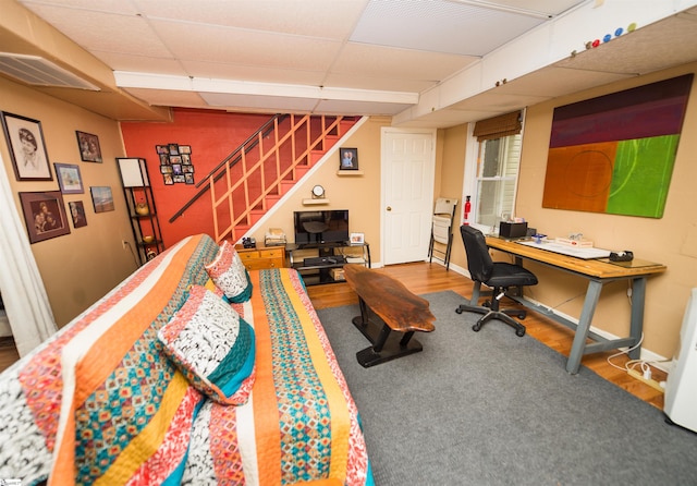 interior space with a paneled ceiling and hardwood / wood-style floors