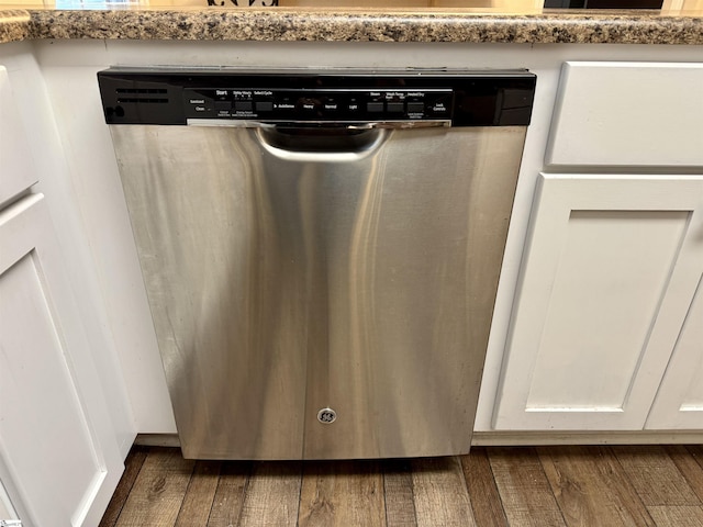 details featuring white cabinetry, dishwasher, dark wood-type flooring, and light stone countertops