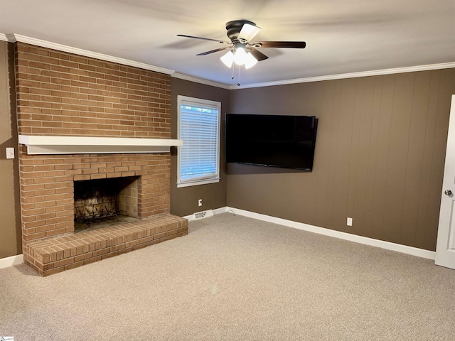 unfurnished living room with crown molding, carpet, ceiling fan, and a brick fireplace